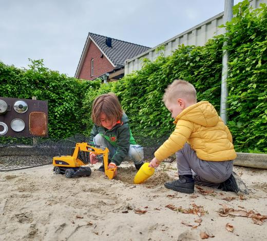 Twee jongens spelen in de zandbak